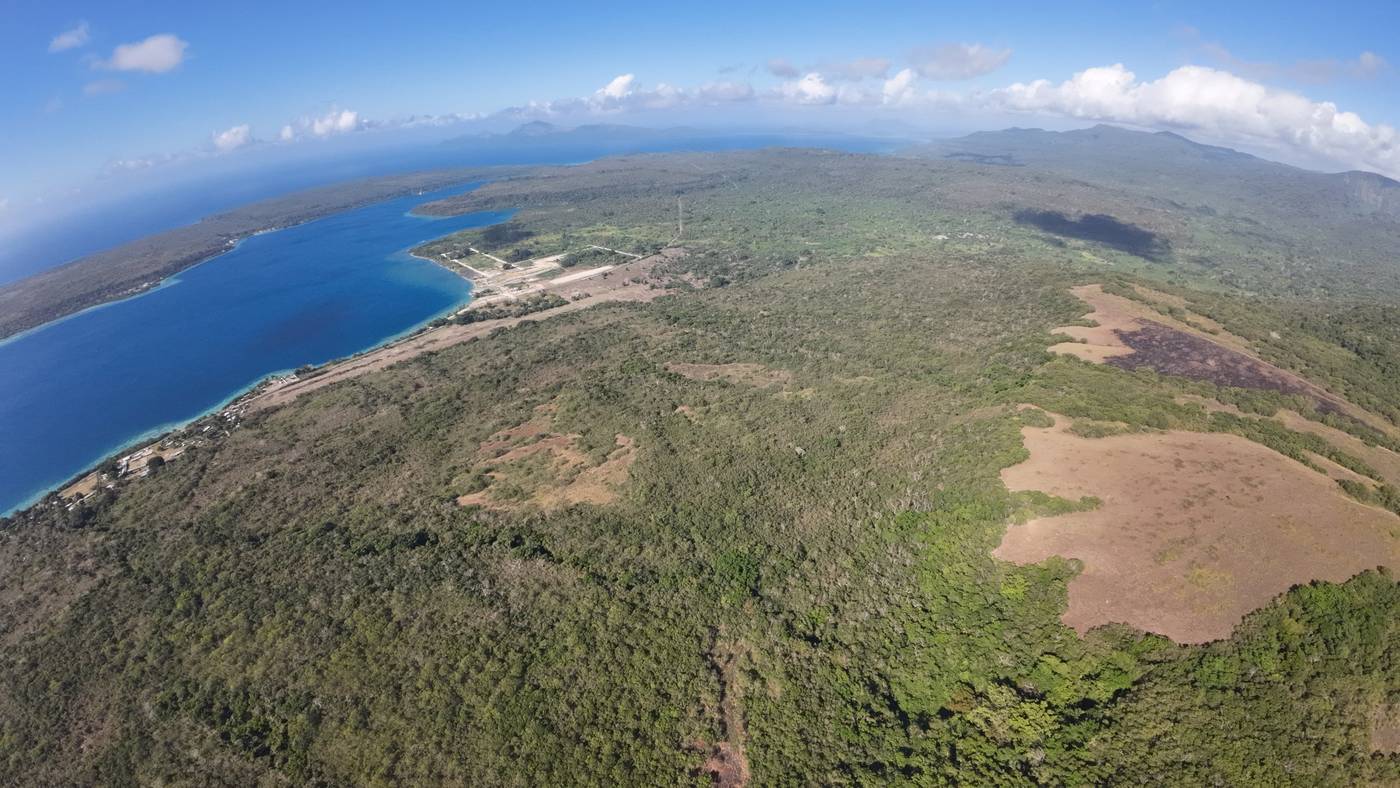 The same stretch of shore today, the strip line still visible beside the harbour
